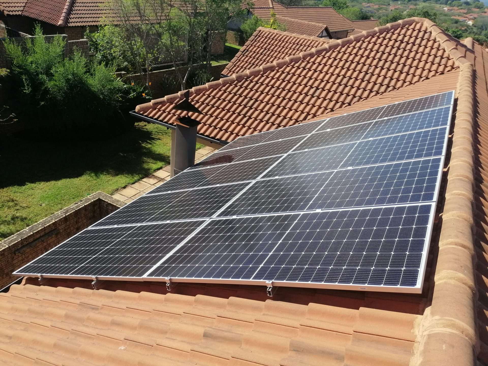 Solar panels on a red tile roof.